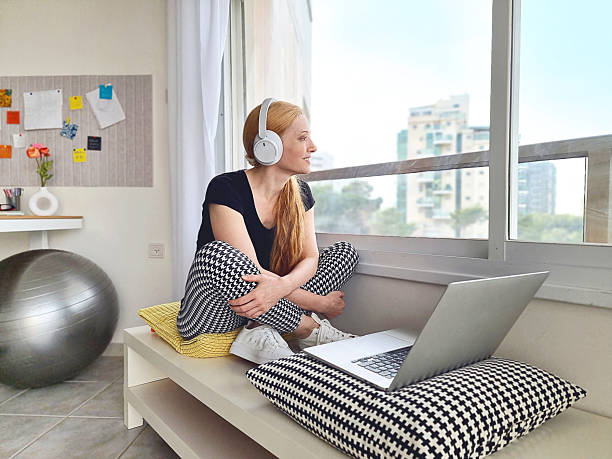 istock Woman at work with headphones looking through a big window 2253173179