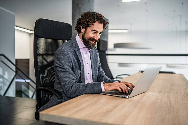 istock Confident businessman working on laptop in modern office 2253174432