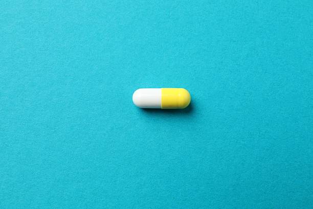 istock Medicine capsule on blue background 2253176288