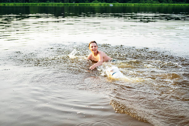 istock Man and Dog Splash in Water During Fetch Game 2253176436