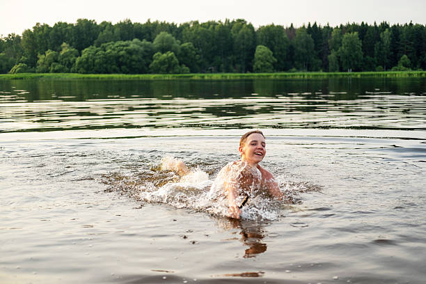 istock Young Boy Swimming in a Lake Surrounded by Nature 2253176636