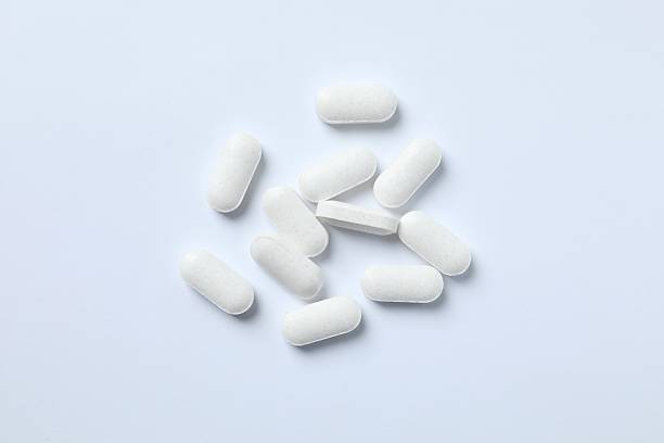 istock White medical pills on light background 2253176920