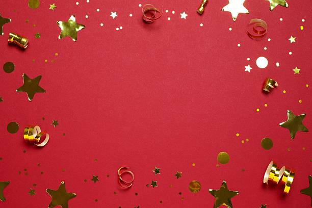 Golden confetti on red background, top view