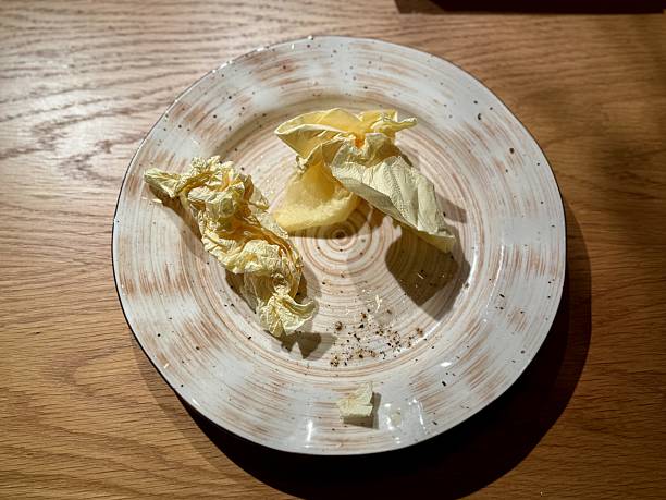 istock Plate with butter and cabbage, rustic ceramic dish on wooden table under warm ambient light, scattered crumbs and butter shavings, intimate bistro vibe, quiet after meal moment 2253177814
