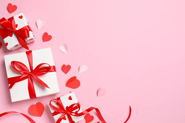 istock Fedtive gift boxes with red hearts on pink background 2253178943