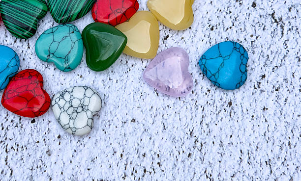 istock Colorful heart-shaped stones on white textured background 2253179647
