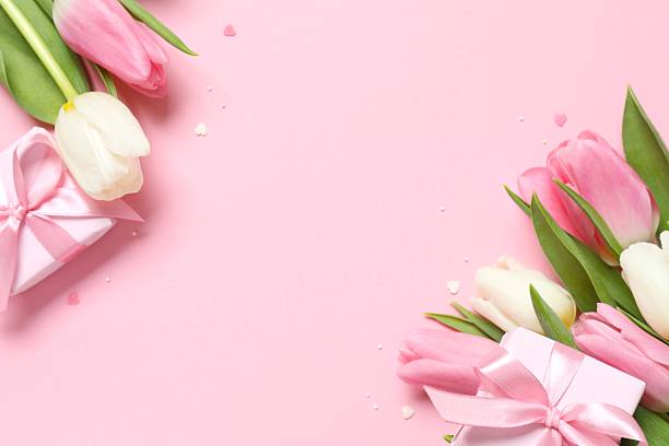 istock Beautiful fresh tulips with gift boxes on pink background 2253179829