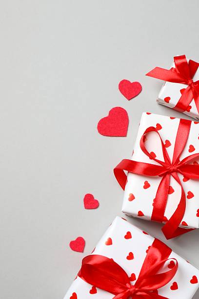 istock Festive gift boxes with red hearts on grey background 2253180320