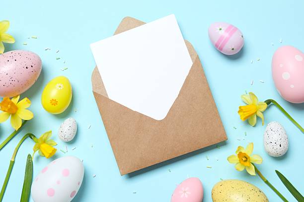 istock Happy Easter. Colorful eggs, paper envelope and yellow flowers on color background, space for text or advertising 2253180705