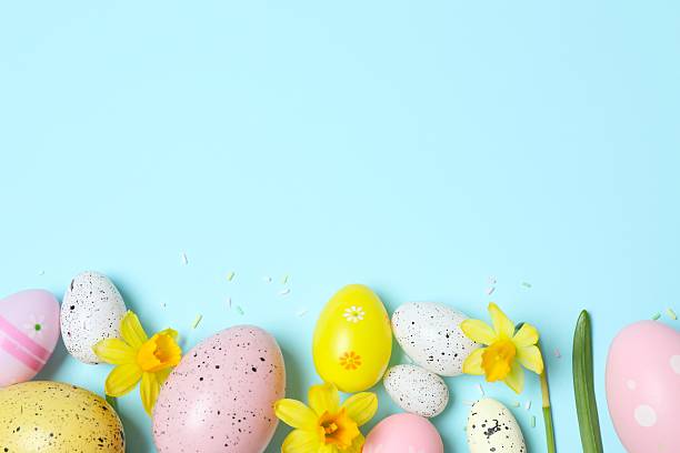 istock Happy Easter. Colorful eggs and yellow flowers on color background, space for text or advertising 2253180706