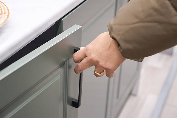 istock Opening a cabinet with a sleek handle in modern kitchen 2253181428