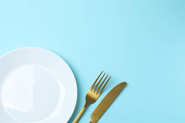 istock White empty plate cutlery on blue background 2253181727