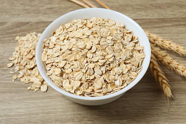 istock Composition with oatmeal flakes on gray background. Cooking breakfast 2253183236