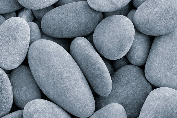 Two stones on the beach. Pebbles on a steel surface with a cloudy sky in the background