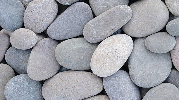 istock Pebbles stones on seashore as  texture background for design web banner template page. SPA concept background 2253183897