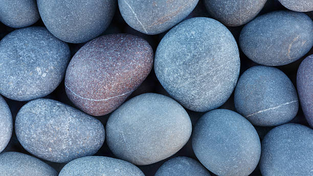 istock Pebbles stones on seashore as  texture background for design web banner template page. SPA concept background 2253183913