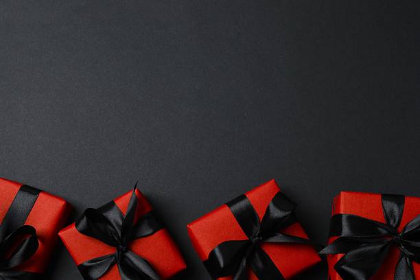 istock Stylish red gift boxes on a black background, festive and holiday concept 2253184012