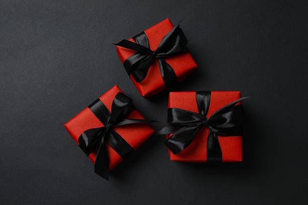 istock Stylish red gift boxes on a black background, festive and holiday concept 2253184013