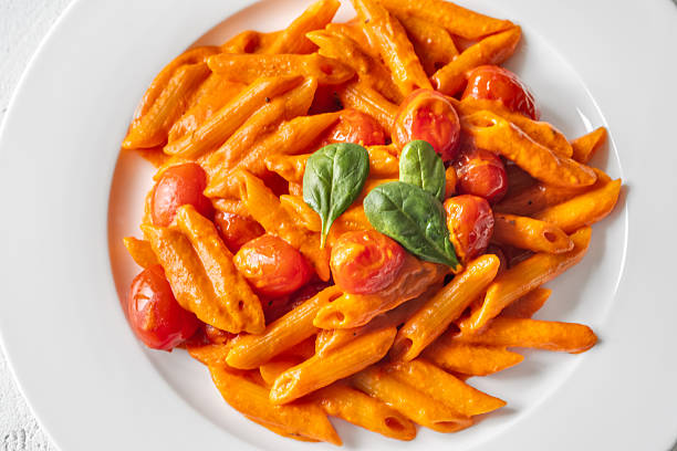 Homemade Italian pasta dish showcasing roasted peppers fresh tomatoes and aged Parmesan