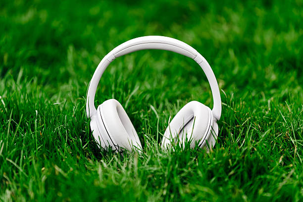 istock White wireless headphones resting on vibrant green grass 2253185261