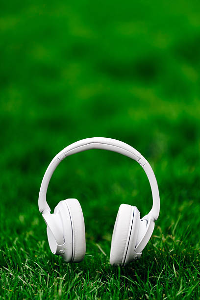istock White wireless headphones resting on vibrant green grass 2253185380