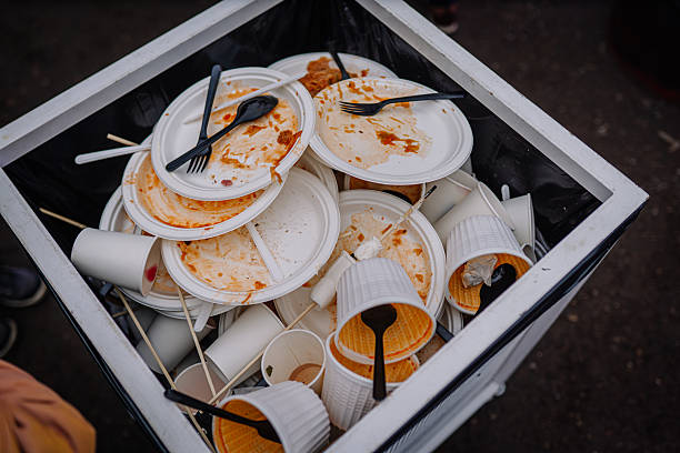 istock Overflowing trash bin filled with used disposable plates, cups, and utensils, showcasing the aftermath of a busy outdoor event with food remnants and waste materials 2253185456