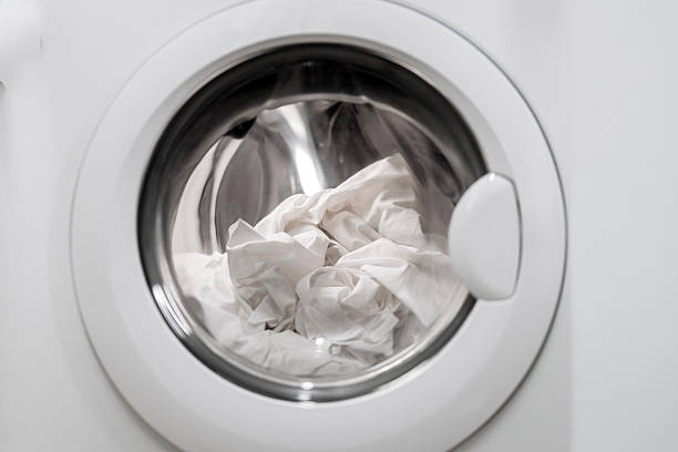 istock Washing machine with transparent door showcasing white laundry inside 2253185507