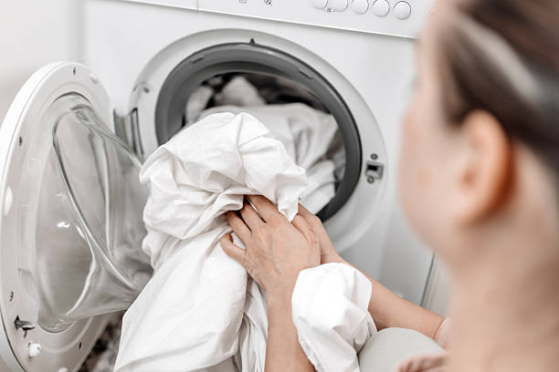 istock Hands of a person pulling a fluffy white towel from a modern washing machine 2253185517