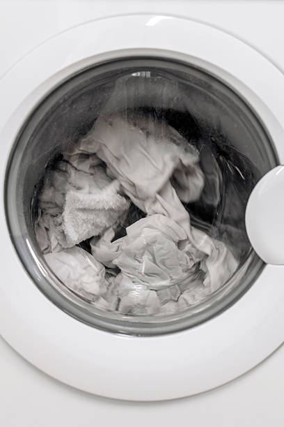istock Washing machine with transparent door showcasing white laundry inside 2253185570