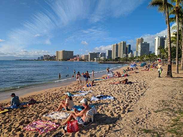 Honolulu, Hawaii - December 21, 2025: Sunbathers at Queens Beach in Waikiki