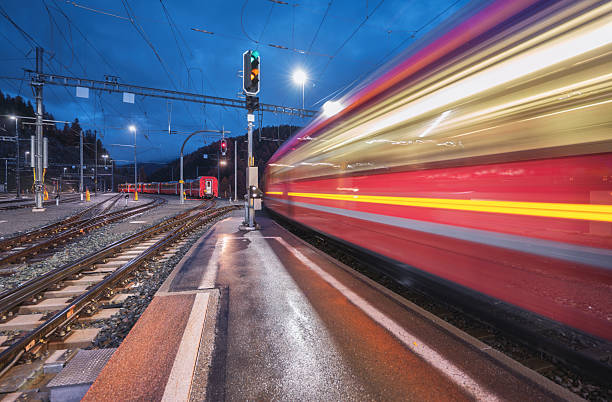 istock Blurred red passenger train passing mountain railway station 2253186667
