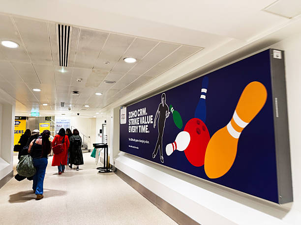 Manchester, UK - December 13, 2025: Shoppers walk through a bright Manchester corridor past a bold bowling pins mural on blue.