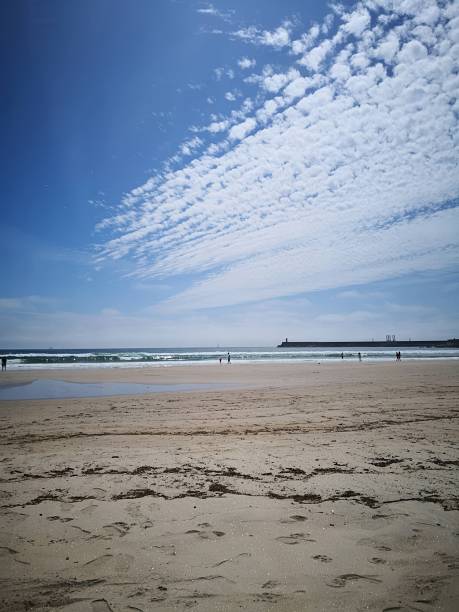 istock A vibrant beach scene under a bright blue sky with scattered clouds 2253187691