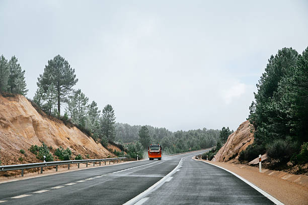 A winter road in a forest area with a snowplow truck