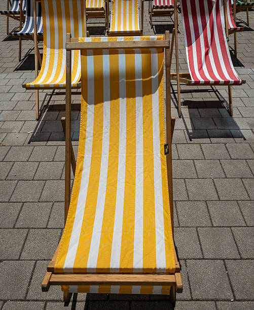 istock striped yellow deck chair on sunny pavement 2253192448