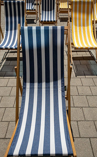istock blue striped deck chair in sunny outdoor setting 2253192452