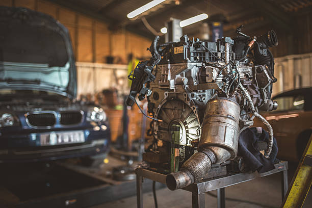 Local mechanic repairing car engine at night on his workshop.