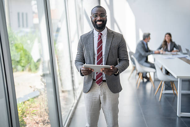 istock Smiling businessman holding digital tablet in modern office 2253195289