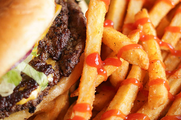 Classic American cheeseburger served with french fries in a basket, photographed in natural light. Juicy beef patty with melted cheese, lettuce, onion, and pickles on a soft bun, presented as casual comfort food. Ideal for restaurant, diner, fast casual dining, burger, lunch, dinner, and American cuisine concepts