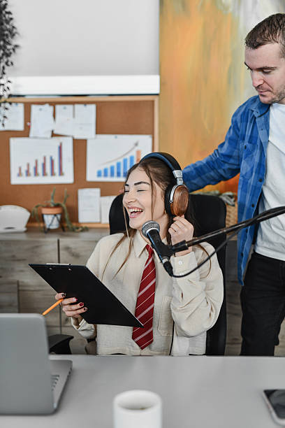 istock Happy Female Host With Headphones And Microphone In Office Interview Setup 2253200774