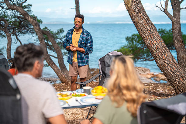 Friends Share Scenic Coastal Breakfast While Listening To Speaker Outside