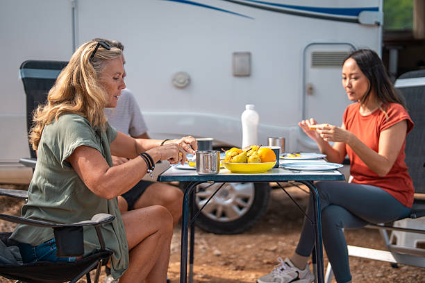 Two Friends Enjoying Morning Meal Together Near Parked Motorhome