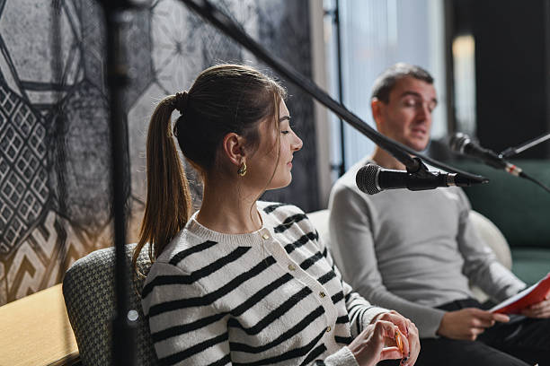 istock Two Hosts Interviewing Guests In A Cozy Studio With Microphones And A Live Show Setting 2253201531