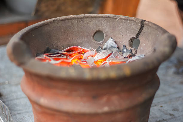 a traditional clay charcoal stove with burning charcoal inside
