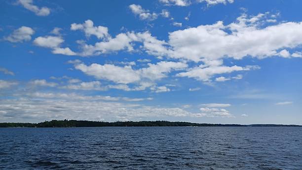 istock Speedboat Crossing Vast Blue Lake Shore 2253205068