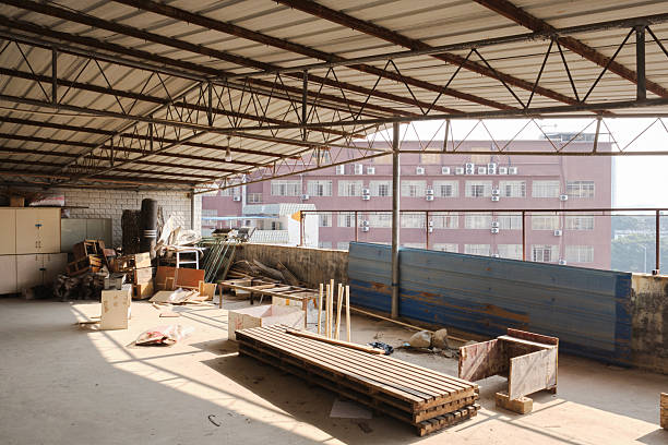 Engineers, architects and blue collar workers in protective clothing working in factory with modern machinery