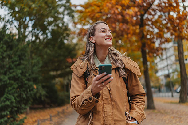 istock Person enjoying autumn in a park in Berlin while using mobile phones during the weekend 2253209692
