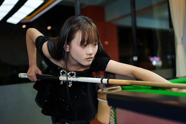 istock An Asian young woman playing billiards. 2253214944