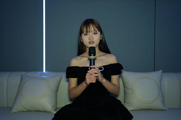 A young person holding a microphone, ready to sing.