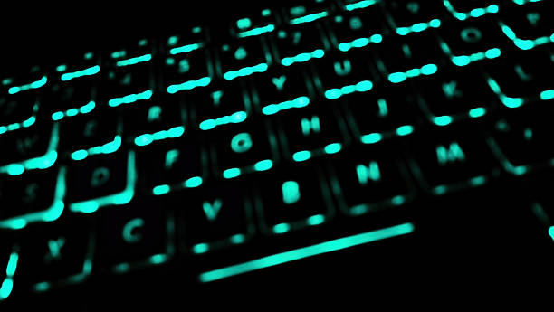 istock Close up on a glowing keyboard with black keys and light blue illumination. The keyboard suggests technology, gaming, and modern design, ideal for concepts related to computing and innovation. 2253215235
